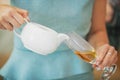 Woman pouring tea into wine glass. Non alcoholic drink Royalty Free Stock Photo