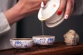 Woman pouring teacup in traditional chinese teaware. Royalty Free Stock Photo