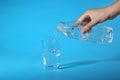 Woman pouring water from bottle into glass on blue background Royalty Free Stock Photo