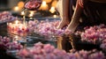 Woman pouring water into bowl with flowers in spa salon, closeup