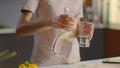 Woman pouring water into glass from jug. Lady drinking water at home Royalty Free Stock Photo