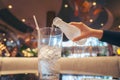 Woman pouring water into glass from plastic bottle background blur restaurant Royalty Free Stock Photo