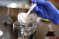 Woman pouring water from metal spoon into glass cup Royalty Free Stock Photo