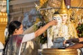 Woman pouring water over Buddha statue Royalty Free Stock Photo