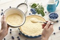 Woman pouring whipped cream into pie crust