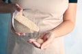 Woman pouring white quinoa from jar into hand