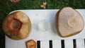 Coconut water pouring from fresh whole coconut into glass