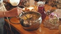 A woman pours hot soup for guests. Royalty Free Stock Photo