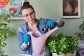 Woman pours liquid mineral fertilizer, in watering can with water