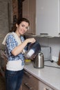 Woman pours water into the teapot from the filter Royalty Free Stock Photo