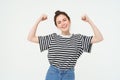 Woman power and feminism. Young girl feeling empowered and strong, flexing her biceps, showing muscles on arms, standing Royalty Free Stock Photo