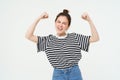 Woman power and feminism. Young girl feeling empowered and strong, flexing her biceps, showing muscles on arms, standing Royalty Free Stock Photo