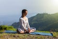 Woman practice yoga asana Baddha Konasana outdoors