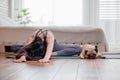 Woman practice yoga with dog pug breed Royalty Free Stock Photo