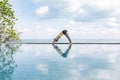 woman practice yoga Downward Facing dog or yoga Adho Mukha Svanasana pose meditation summer vacation on the pool