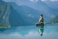 Woman practice yoga on the pool above the Mountain peak Royalty Free Stock Photo