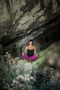 Woman practice yoga meditation in small cave