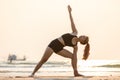 Woman practice yoga Triangle pose to meditation summer vacation on the the beach