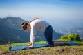 Woman practices yoga asana Marjariasana outdoors Royalty Free Stock Photo