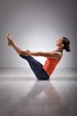 Woman practices yoga asana Paripurna navasana