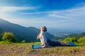 Woman practices yoga asana Urdhva Mukha Svanasana outdoors Royalty Free Stock Photo