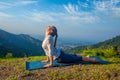 Woman practices yoga asana Urdhva Mukha Svanasana outdoors Royalty Free Stock Photo