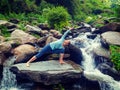 Woman practices yoga asana Utthita Parsvakonasana outdoors