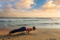 Woman practices yoga at the beach on sunset Royalty Free Stock Photo