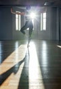 A woman practices yoga in a fitness room at dawn. Concentration, beautiful sunshine, stretching, healthy lifestyle.