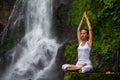 Woman practices yoga at Gitgit waterfall on Bali in indonesia Royalty Free Stock Photo