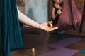 Woman practicing anti-gravity yoga in a hammock indoors. Close-up of a female hand in a meditation pose. Focus on hand