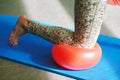 woman practicing balance pose during pilates training, using soft ball for knee Royalty Free Stock Photo