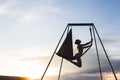 Woman practicing fly dance yoga poses in hammock outdoors at sunset Royalty Free Stock Photo