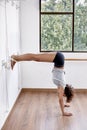 Woman practicing iyengar yoga using wall ropes in studio Royalty Free Stock Photo