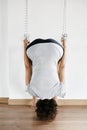 Woman practicing iyengar yoga using wall ropes in studio Royalty Free Stock Photo