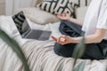 Woman practicing morning meditation on bed against laptop Royalty Free Stock Photo