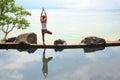 Woman practicing morning meditation Yoga at the beach