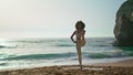 Woman practicing pose balance on beach at sunrise. Girl standing on one leg.