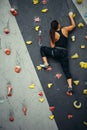 Woman practicing rock climbing on artificial wall indoors. Active lifestyle and bouldering concept. Royalty Free Stock Photo