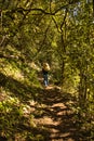 Woman practicing trekking on a path inside the forest