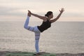 Woman practicing yoga on the beach. King Dancer Pose, Natarajasana. Outdoors sports. Healthy living. Royalty Free Stock Photo