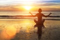 Woman practicing yoga on the beach in the glow of an amazing sunset. Royalty Free Stock Photo