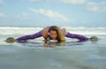 Young happy and attractive girl doing flexibility exercise with legs split  on sand in wellness harmony health care and fitness Royalty Free Stock Photo