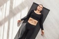 Woman practicing yoga, doing shavasana exercise, relaxation pose, lying on mat in sportswear in room Royalty Free Stock Photo