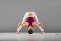 woman practicing yoga doing standing straddle forward bend pose,