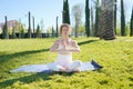 Woman practicing yoga exercises in Park. Healthy mind and strong body. Summer outdoor activity. Relaxation and meditation Royalty Free Stock Photo