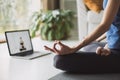 Woman practicing yoga at home. Online video training. Girl doing exercises and meditate. Royalty Free Stock Photo