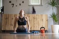 Woman practicing yoga making a cobra pose at home