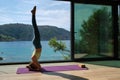 Woman practicing yoga on mat in headstand