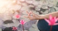 Woman practicing yoga, meditating by the red lotus lake